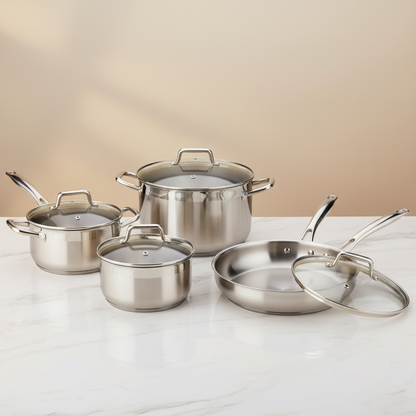 Batterie de cuisine professionnelle inox 7 pièces sur fond marbre blanc lumière dorée